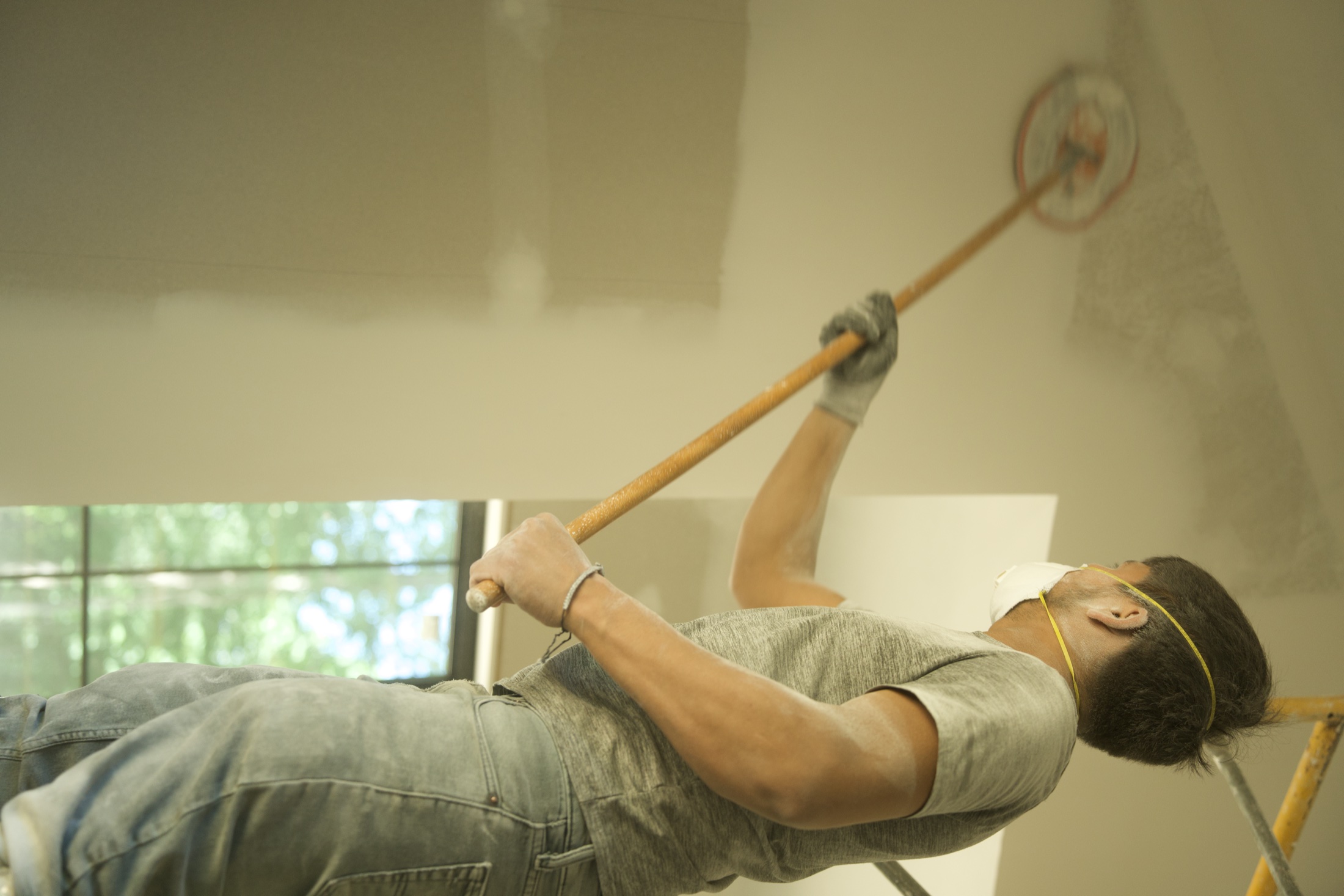 Drywall finisher smoothing a wall by hand